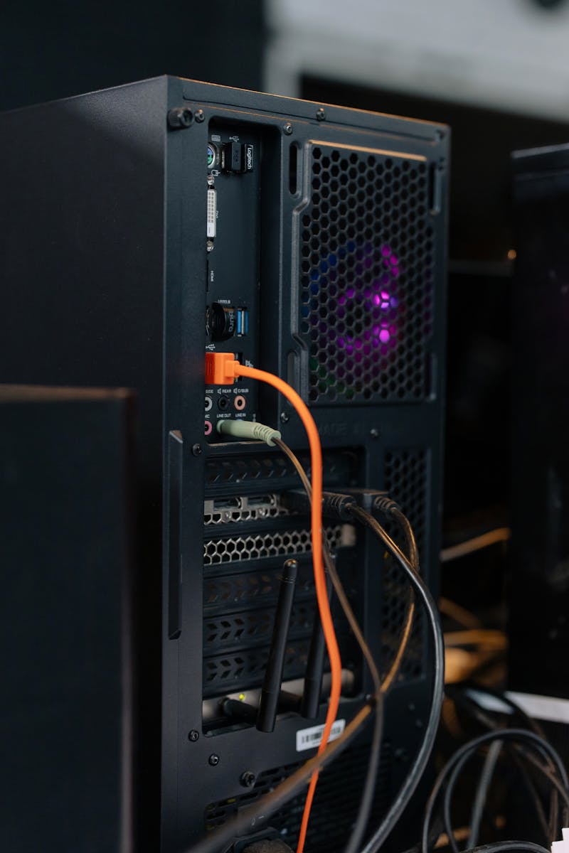 Nahaufnahme eines Desktop-PC-Gehäuses mit angeschlossenen Kabeln und interner Beleuchtung.
